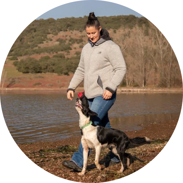 Alexandra, d'Eduk Ton Toutou, au bord d'un lac avec un chien noir et blanc